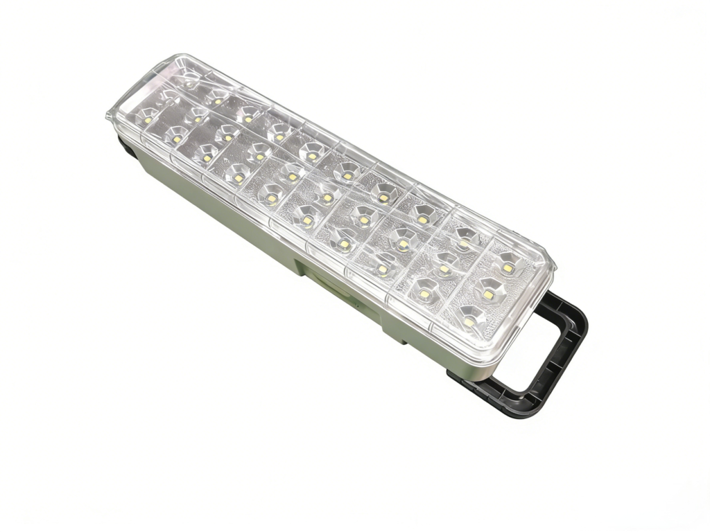 Lámpara de emergencia LED portátil de forma rectangular con asa de transporte negra desplegada y cubierta transparente, aislada sobre fondo blanco.